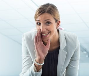 Woman telling a secret at work