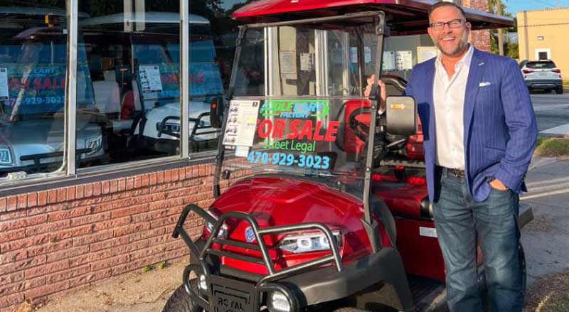 Golf Cart Factory Owner, Erik Sims, alongside a Royal EV outside the showroom