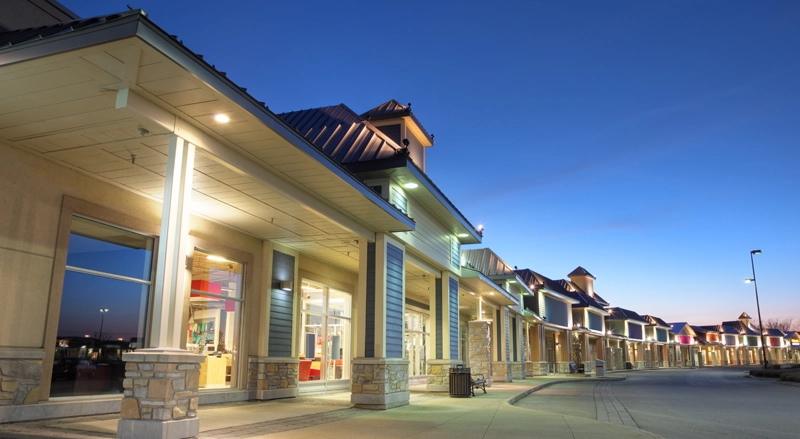 A row of stores in a strip mall at dusk