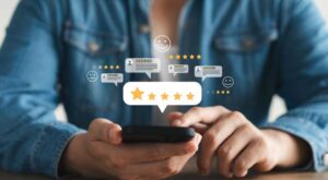 Close-up of a person holding a smartphone with digital 5-star rating icons and positive review symbols floating above the screen