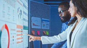 Marketing team analyzing data dashboards and performance metrics for campaign optimization