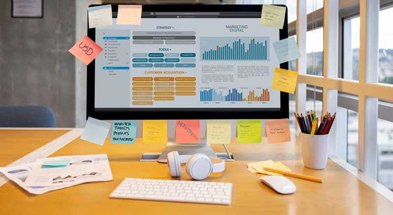 Desktop monitor displaying digital marketing analytics, customer acquisition strategy, and growth performance charts