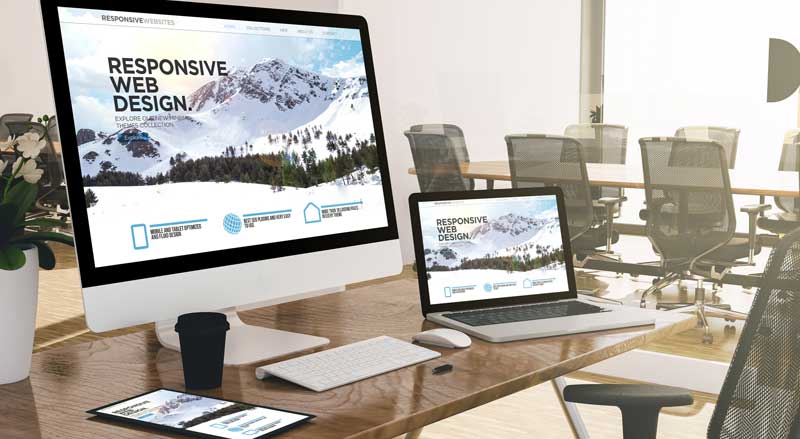 Responsive web design displayed across desktop, laptop, tablet, and mobile devices in a modern office