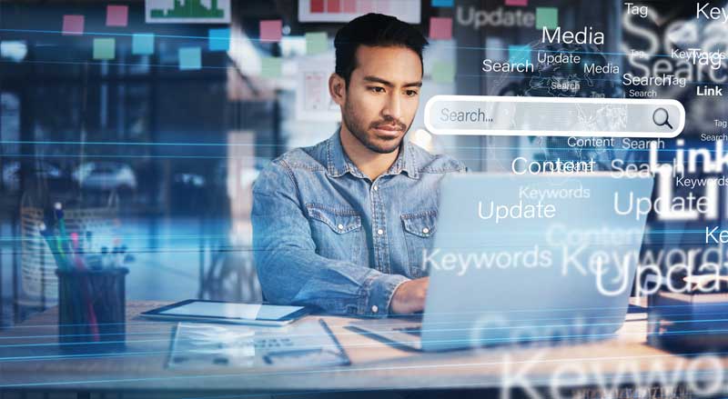 Digital marketer working on SEO and Google Ads optimization with keywords, search rankings, and online visibility graphics displayed on screen