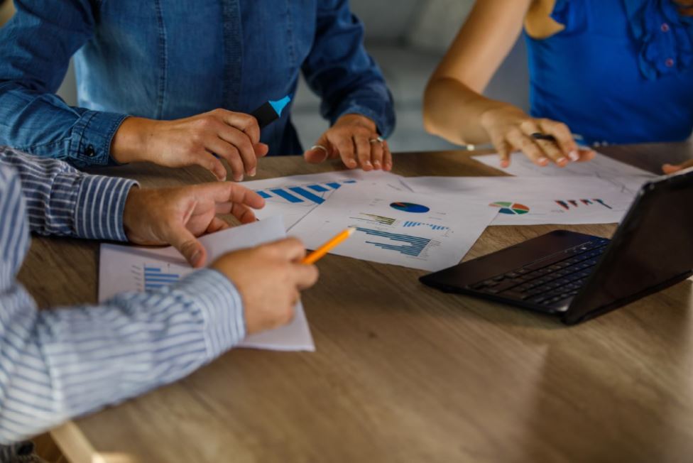 Business leaders reviewing growth strategy, marketing performance, and planning documents during a strategy meeting